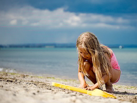 Barn leker på en strand.