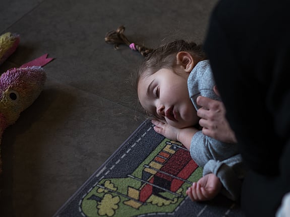 Barn ligger på sidan på golvet.