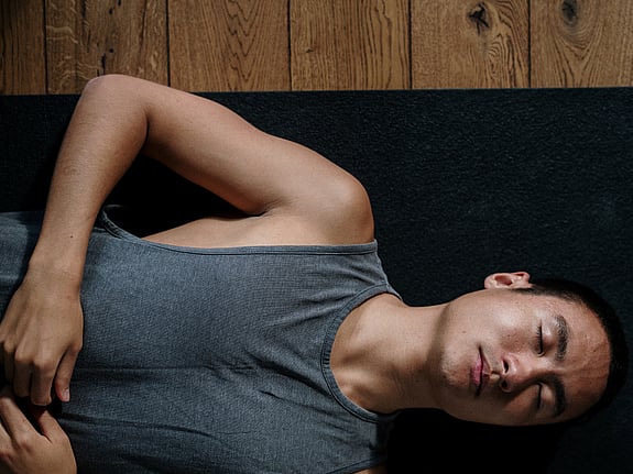 Man som ligger och gör andningsövningar efter fysisk aktivitet