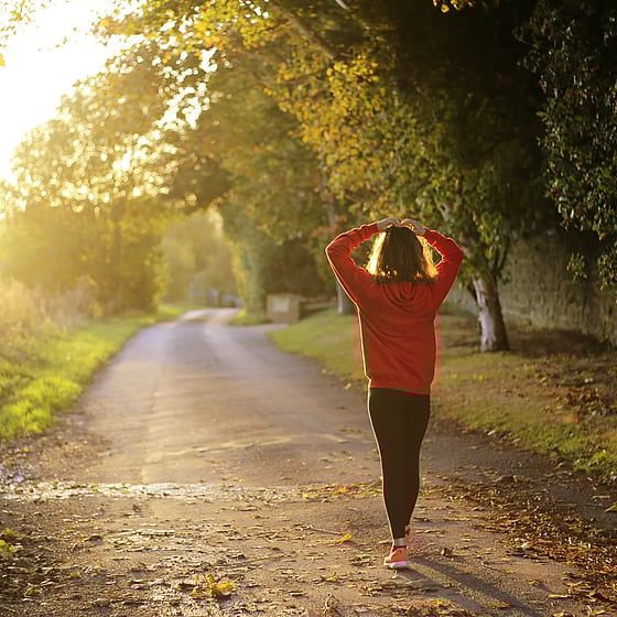 Kvinna som är ute och går i solnedgång