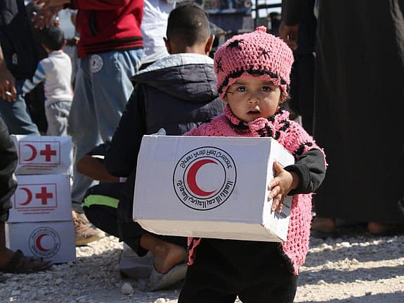 Flicka håller i matpaket.