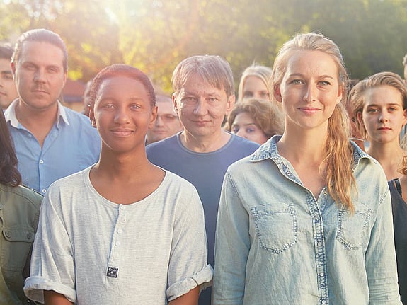 Flera medlemmar tittar in i kameran och ler.