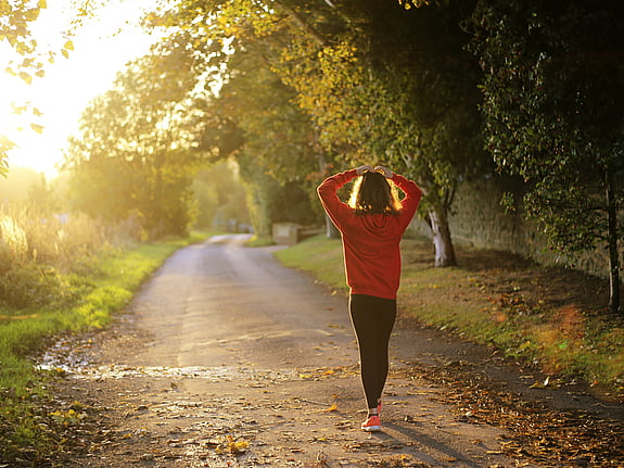 Kvinna som är ute och går i solnedgång