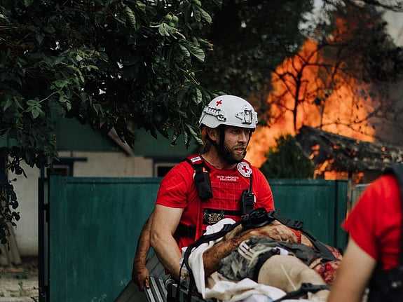 Sjukvårdare med eld i bakgrunden