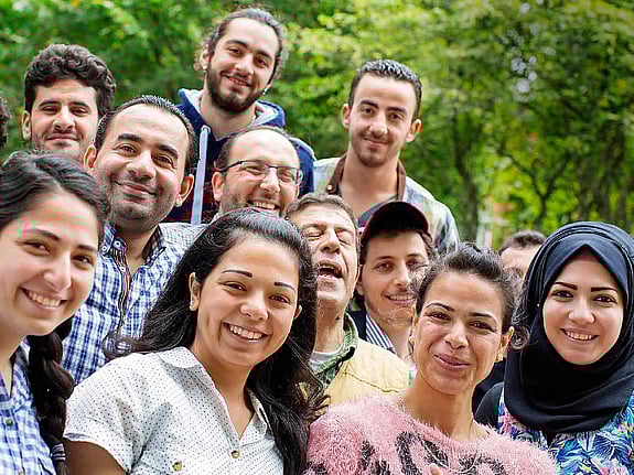 Flera medlemmar tittar in i kameran och ler.