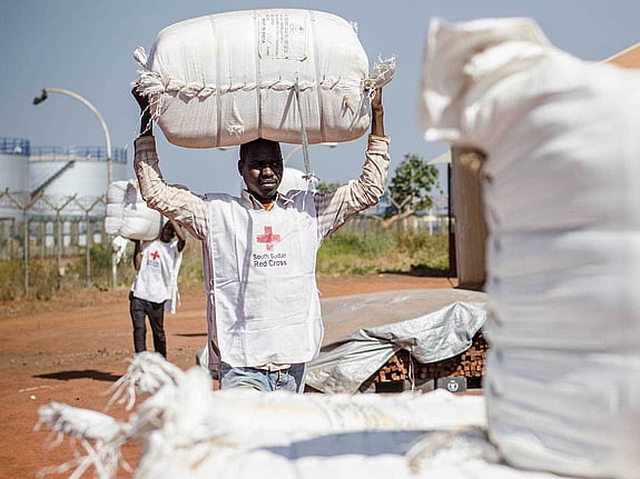 Lokalvolontär bär på vit säck