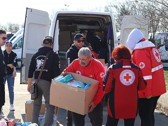 Rumänska röda kors-volontärer vid skåpbil