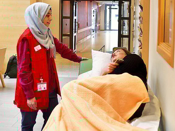 Rödakorsvärd lyssnar på sängliggande patient