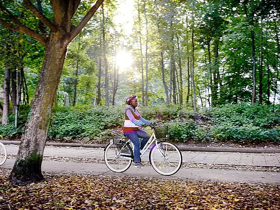 Kvinna cyklar på skogsväg