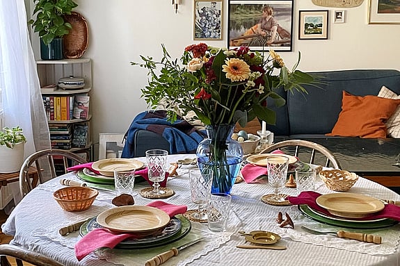 dukning-med-vas-och-blommor-med-bestick-och-tallrikar-fran-roda-korset-second-hand