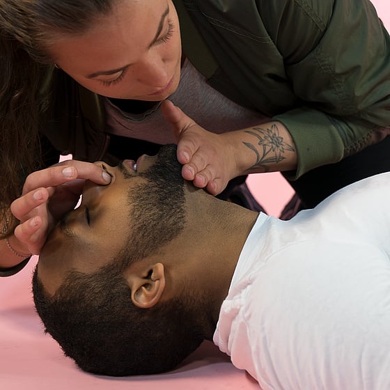 Medvetslös person får hjälp med första hjälpen och HLR.