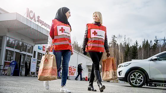 Röda Kors volontärer bör matkassar utanför ICA.