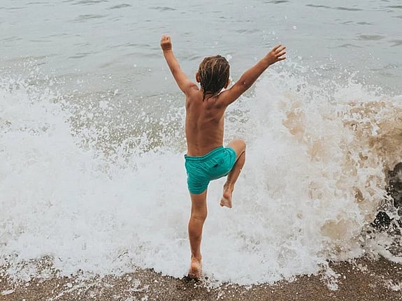 Barn som badar i havet