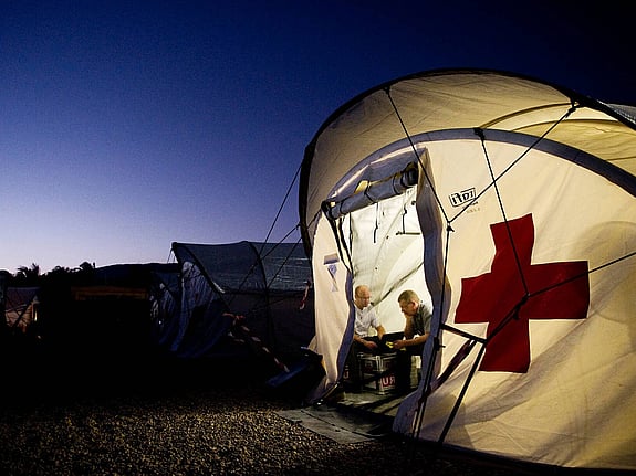 Upplyst tält med röda korset på.