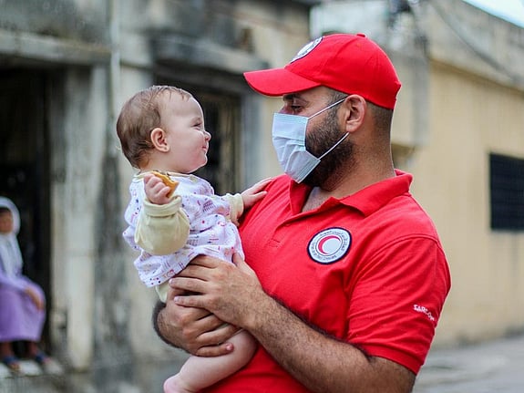 En pojke tittar in i kameran och ler.