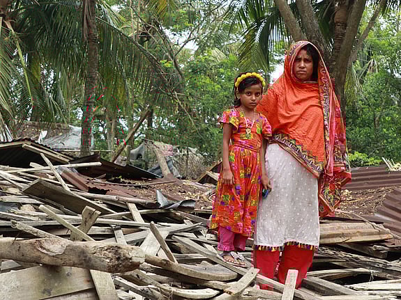 Kvinnor står framför bråte.