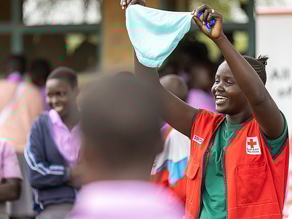 En volontär från Röda Korset håller upp en trosa framför skolelever i Sydsudan.