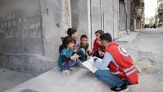 Volontär samtalar med barn i Syrien