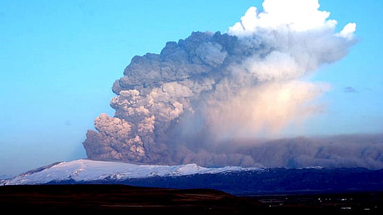 Askmoln mot blå himmel efter vulkanutbrott