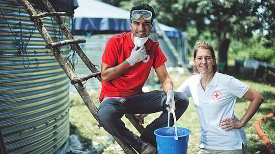 Farzad Farzaneh och Röda Korskollega framför vattenreningsverk i Uganda.