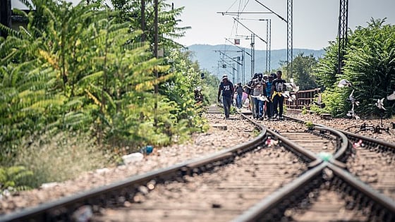 En grupp personer går längs en tågräls.