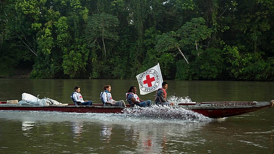 Båt åker över flod med flera passagerare