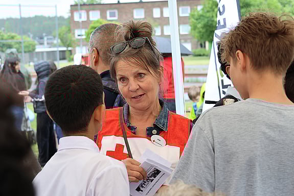 En person som pratar med två barn