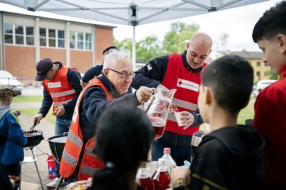 Sven-Erik Sjöstrand och Samir Makhlouf serverar korv och saft.