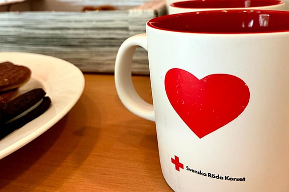En kopp kaffe står på ett bord tillsammans med kakor.