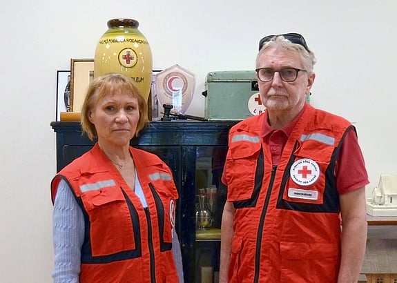 Titti (till vänster) och Kenneth (till höger) står iklädda sina röda korset-västar och tittar in i kameran.