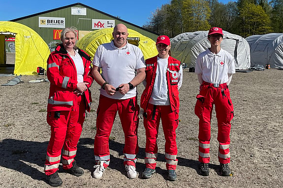 Fyra volontärer står med rödakorskläder.