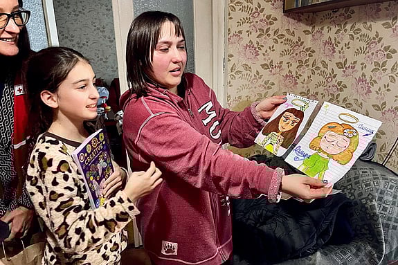 Maryna visar upp teckningar som hennes dotter ritat i deras hem i Moldavien.