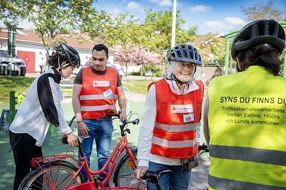 Volontärer intill flickor som lär sig att cykla