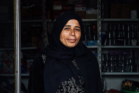 Leende kvinna i sin matbutik.