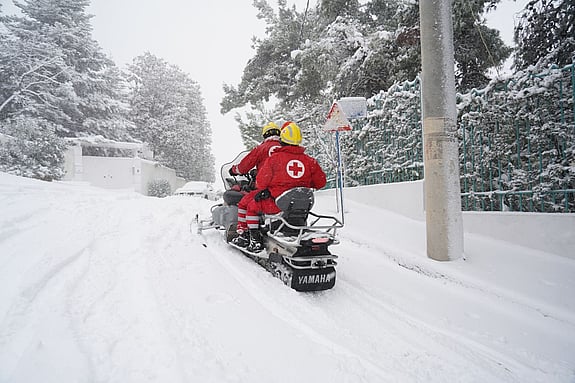 Snöskoter från Röda Korset hjälper efter snöstorm i Grekland.