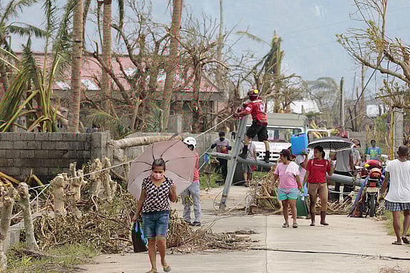 Två män sitter på huk bland bråte.