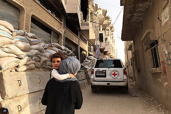 Mor med barn i förfallen gränd