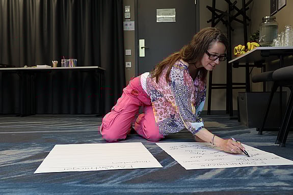 En person som skriver på ett papper på golvet