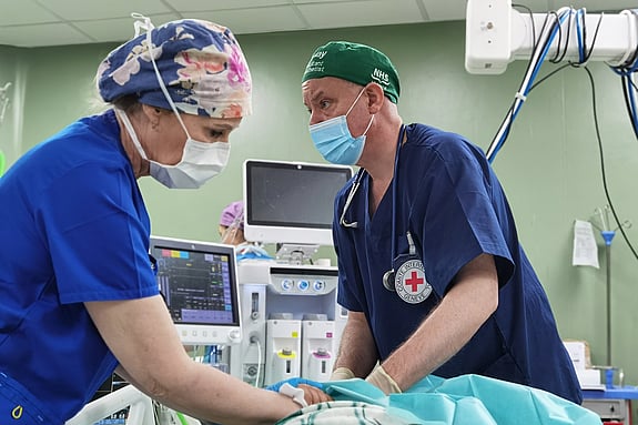 En läkare och en sjuksköterska på ett sjukhus som ger vård till en skadad person.