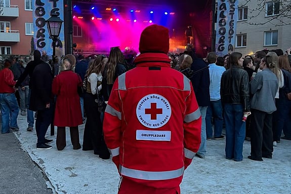 En person med röd väst som tittar mot ett publikhav