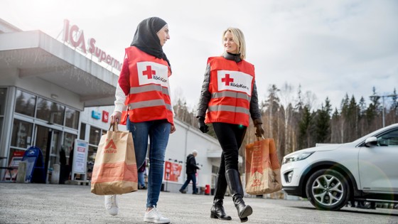 Röda Kors volontärer bör matkassar utanför ICA.