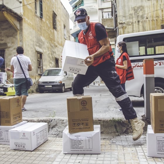 Män lastar av hjälppaket från helikopter