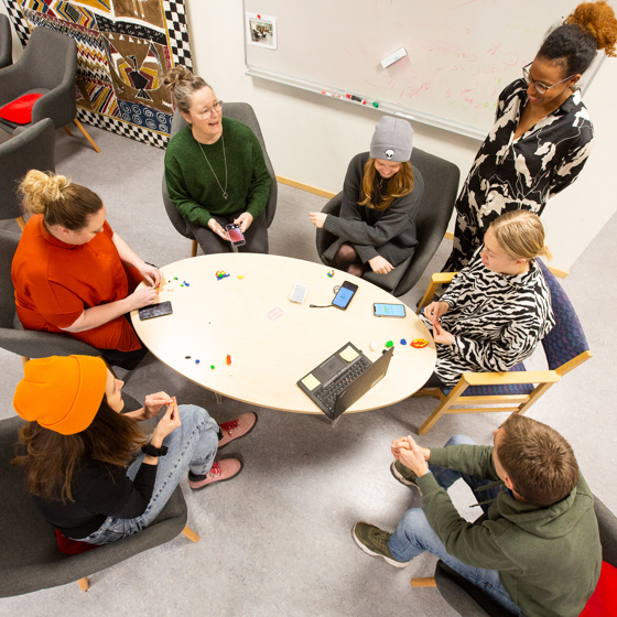 Elever vid Röda Korsets folkhögskola sitter runt ett bord.