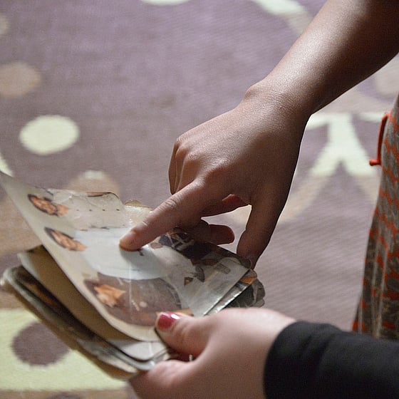 En hand pekar på fotografi av saknade familjemedlemmar.