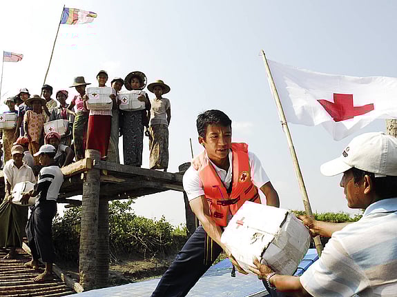 Man lastar av katastrofpaket från båt.