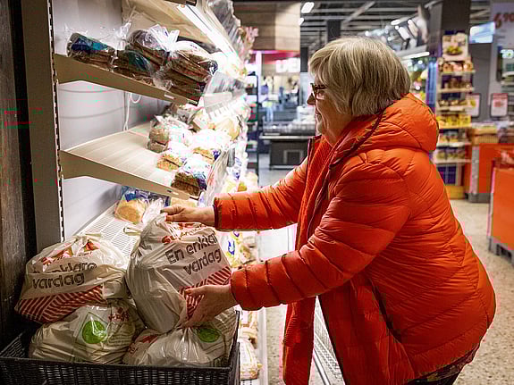 Volontären Gunborg vid brödhyllan.